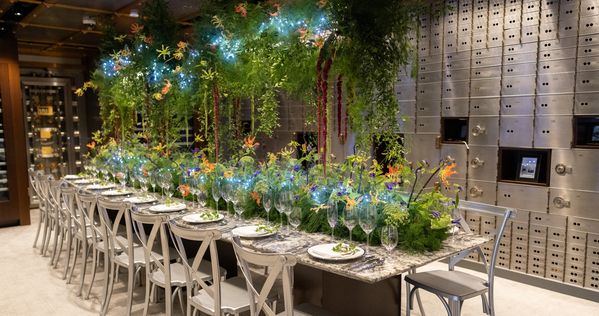 The gorgeous, Black Forest-inspired tablescape, dripping with ferns and greenery, set up within the showroom's vault area.