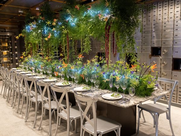 The gorgeous, Black Forest-inspired tablescape, dripping with ferns and greenery, set up within the showroom's vault area. 