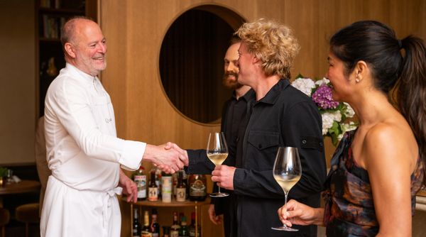 Chefs Michael Tusk and Justin Cogley shaking hands. 