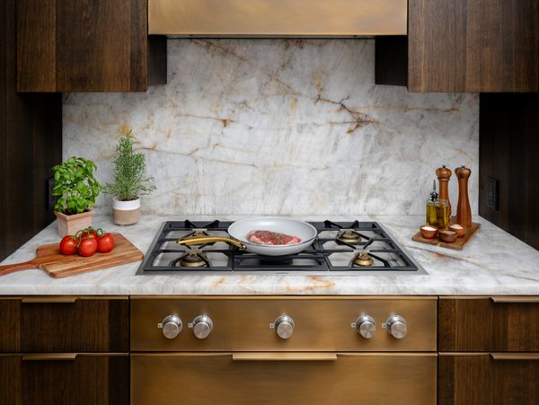 A close-up of the Gaggenau cooktop, with a delicious steak ready to be prepared. 