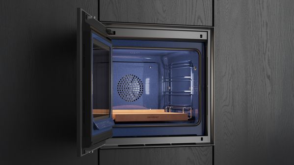 A Gaggenau Expressive series oven with its door open, showing the blue interior and a Gaggeanu baking stone