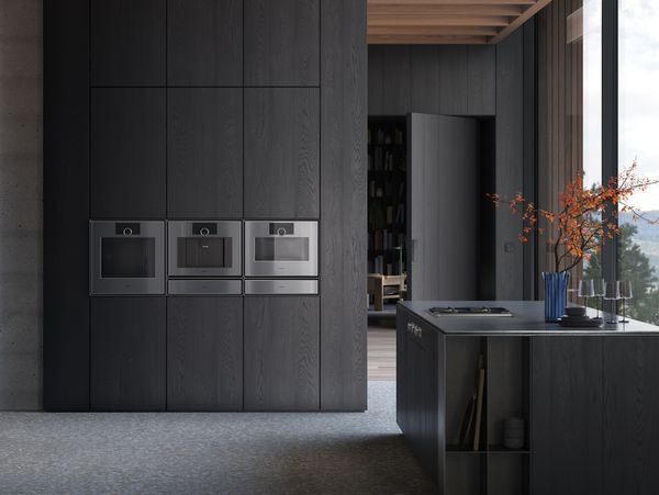 View into an open plan luxury kitchen fitted with Gaggenau Expressive series appliances.