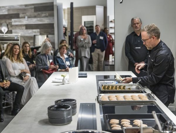 Chef Johnny Spero prepares canapés on a Gaggenau cooktop in front of guests. 