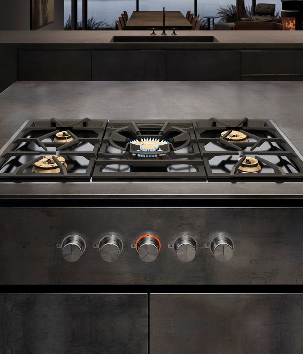 A Gaggenau 5 Burner Vario Gas Cooktop installed in a luxury kitchen with the center burner gas flame visible