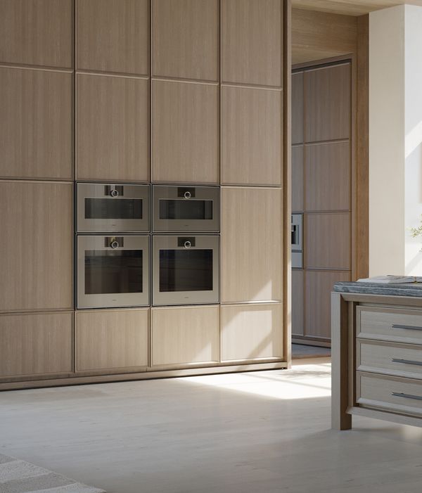 View into an open plan luxury kitchen fitted with Gaggenau Expressive series appliances.