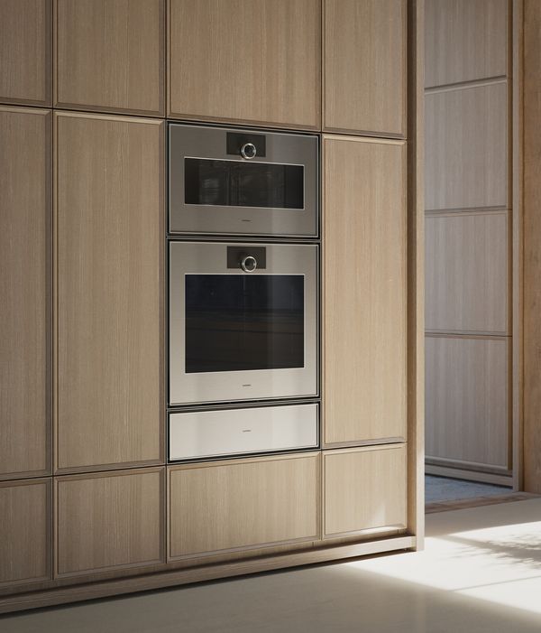 View into an open plan luxury kitchen fitted with Gaggenau Expressive series appliances.