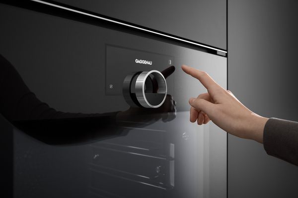 Doigt appuyant sur l&rsquo;&eacute;cran tactile d&rsquo;un four Gaggenau de la s&eacute;rie Minimalistic
