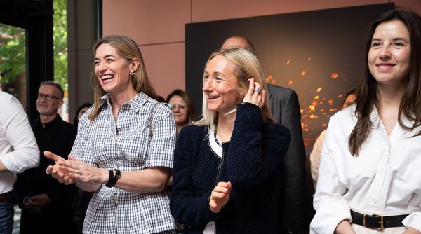 Attendees smiling and clapping during the appliance reveal.