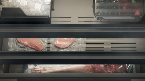 Close-up of a Gaggenau Expressive series fridge-freezer drawer containing ice and frozen food