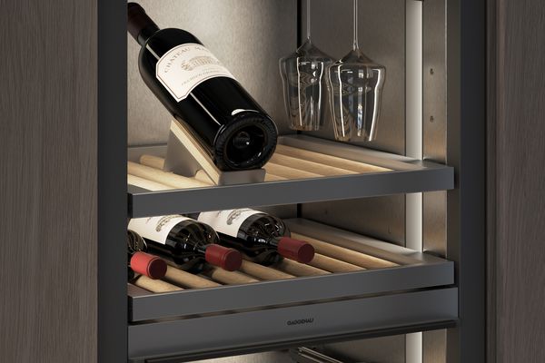 Nahaufnahme des Innenraums aus dunklem, gebürstetem Edelstahl und eines Flaschenaufsatzes aus Weißeiche in einem Weinklimaschrank der Gaggenau Vario Kältegeräte Serie Expressive
