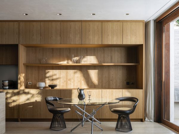 A sunlit dining area with wooden cabinetry and modern furniture