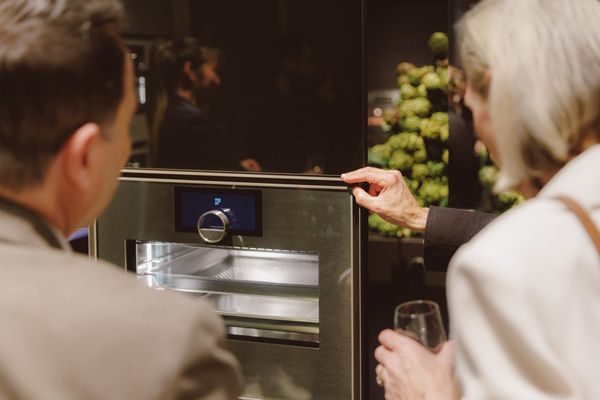 A guest inspects the features of a Gaggenau oven.