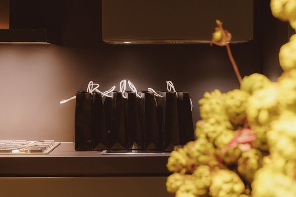 Black gift bags on a countertop with a Gaggenau hob.