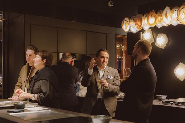 Close-up of attendees discussing around Gaggenau appliances showcased in a modern kitchen.