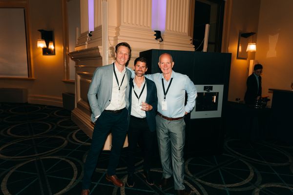Three men posing together, with Gaggenau equipment in the background.