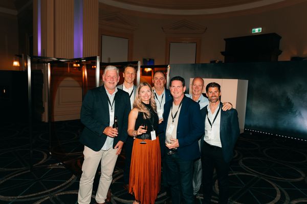 A group of seven guests smiling for a photo at the event.