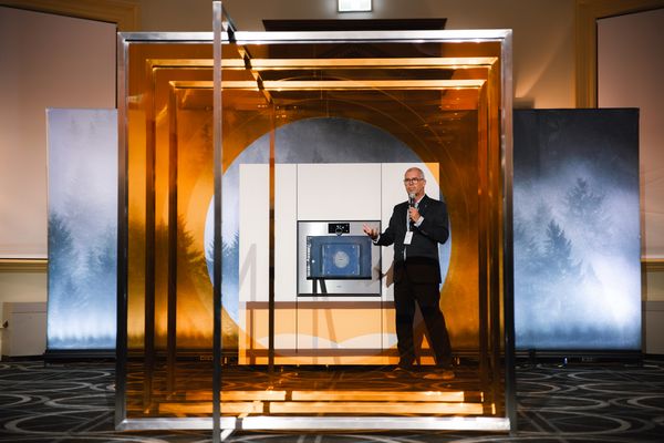 Gaggenau oven showcased on stage, framed by an artistic structure.