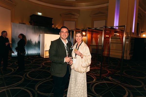 Two guests enjoying drinks near the Gaggenau display at the event.