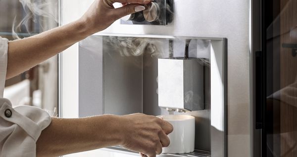 The Gaggenau coffee machine crafting a steaming beverage. 