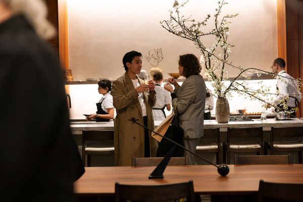 Two people talking with drinks in a kitchen area at the Gaggenau KOTY Awards.