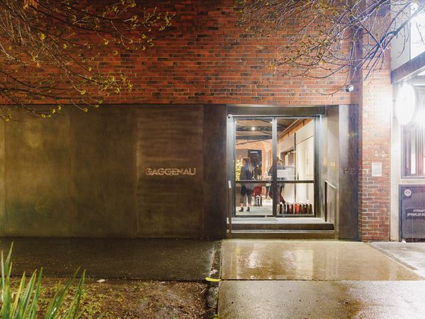 Illuminated exterior of a Gaggenau showroom at night, featuring a brick and metallic facade with the brand logo.