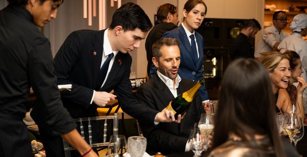 Champagne is served to seated guests.