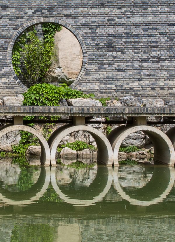 Vista externa através de água do Red Brick Art Museum de Pequim